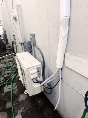 Mini-split condenser installed by AirWise with covered line set and disconnect